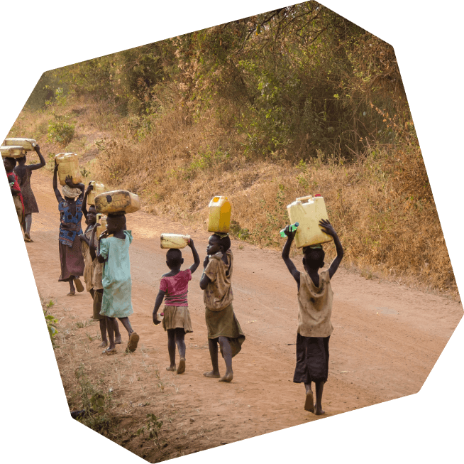 Photograph of children walking with bottles of water on their heads