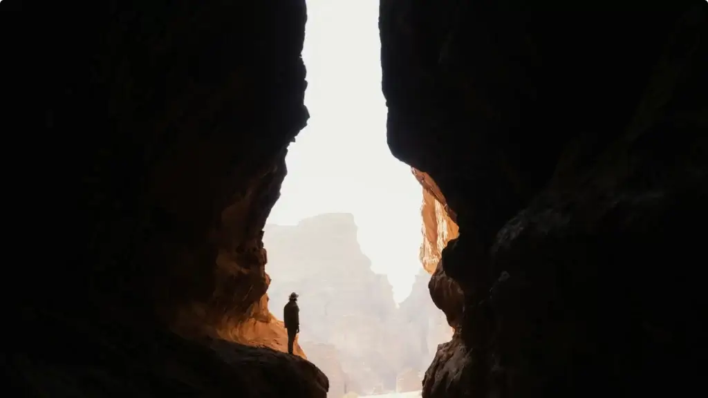 A photograph of a man standing in a chasm, signifying the sin gap between us and Christ that He came to bridge